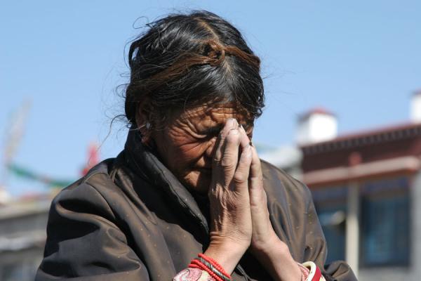 Old woman praying in front of the Jokhang temple