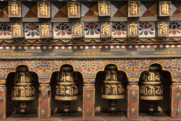 Foto van Row of prayer wheels with painted screen outside Dumtseg LhakhangDumtseg Lhakhang - Bhutan