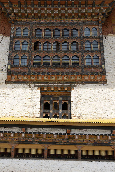 Picture of Intricate decorated window and prayer wheels outside the temple building of Gom KoraGom Kora - Bhutan
