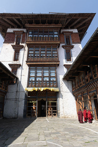 Picture of Courtyard inside Jakar Dzong with a couple of monks in a corner - Bhutan
