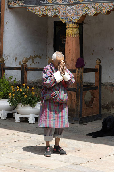 Photo de Praying man in the courtyard of Jambay LhakhangJambay Lhakhang - Bhoutan