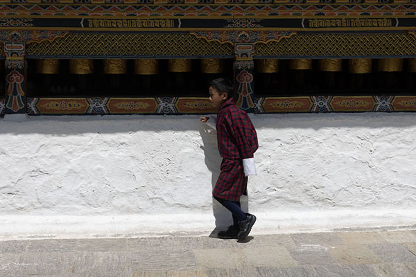 Foto van One of the many worshippers turning the prayer wheels around the Chorten KoraTrashiyangtse Chorten Kora - Bhutan