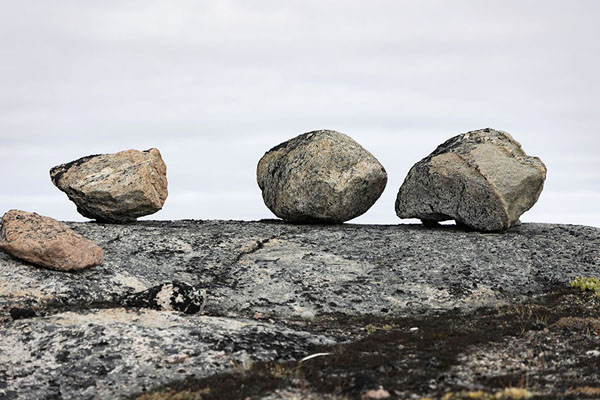 Foto van Row of rock balls lying on top of a rockPaakitsoq - 