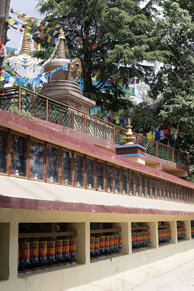 Foto van Row of prayer wheels with religious building along the kora circuitDharamshala - India