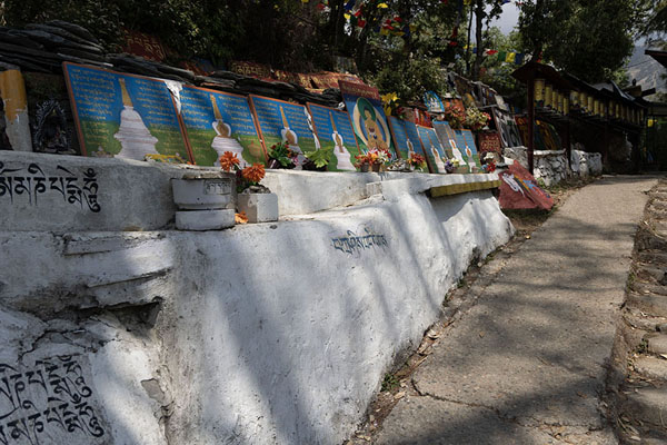 Foto van Wall of the kora circuit with slabs and prayer wheelsDharamshala - India