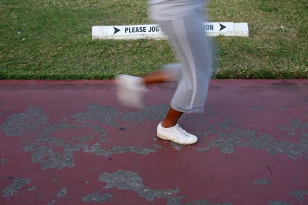 Picture of Emancipation Park (Jamaica): Jogger passing a sign in Emancipation Park