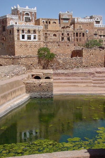 Some of the buildings reflected in the water cistern | Kawkaban | Yemen