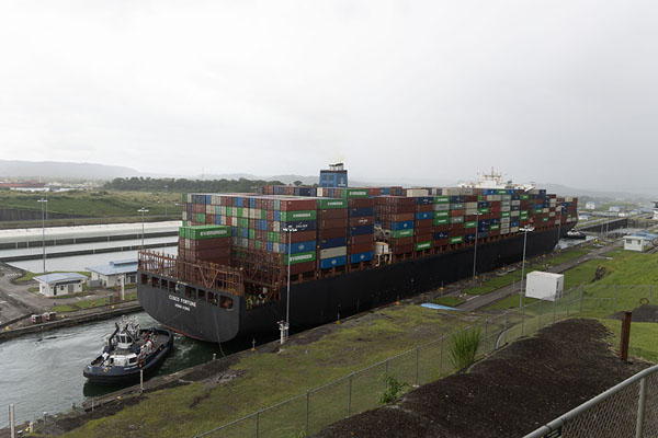 Photo de Tow boat behind a container ship in the Agua Clara locksColón - le Panama